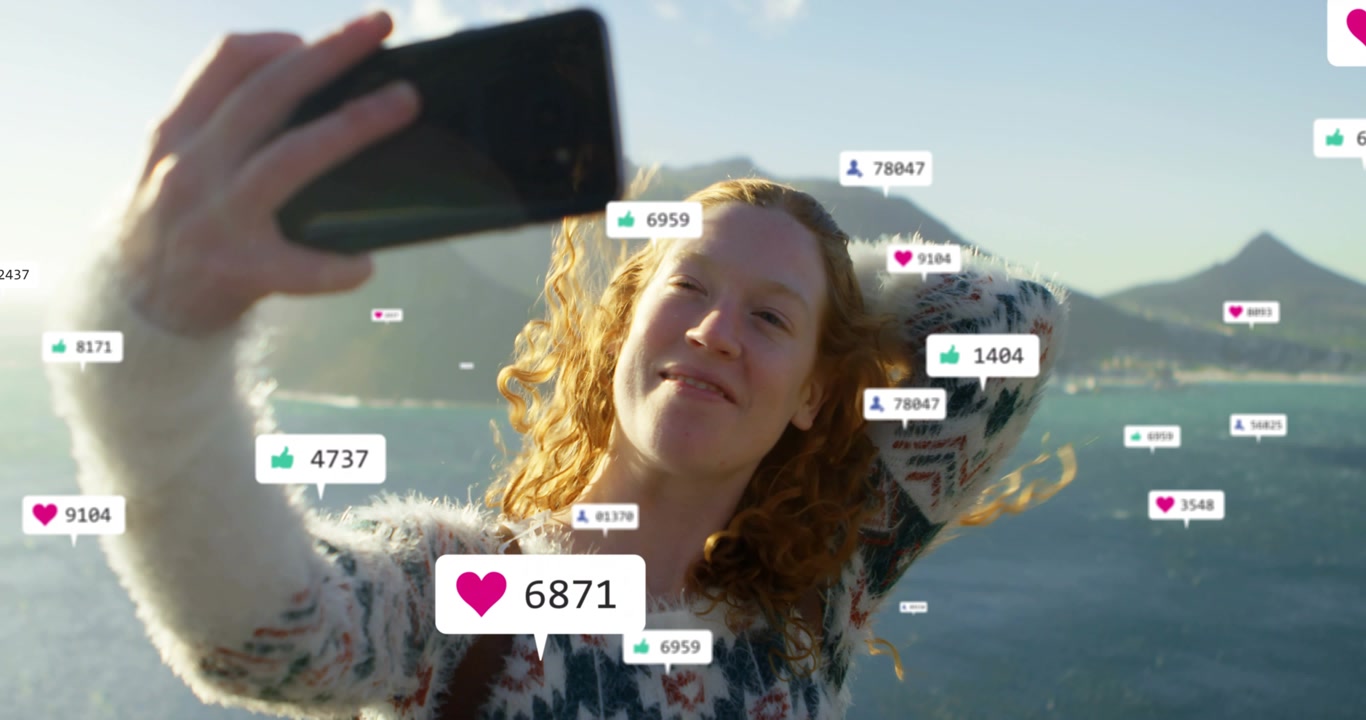 Woman raising phone for selfie on coast posing as social likes growing around her, camera closing