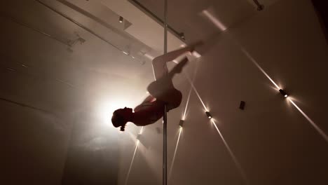 sensual girl dancing in pole bar under studio light
