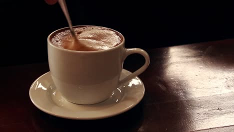 movimiento ambiental de agitar tranquilamente una taza de café espumoso que muestra el tranquilo y pacífico estado de ánimo de otoño y la estética