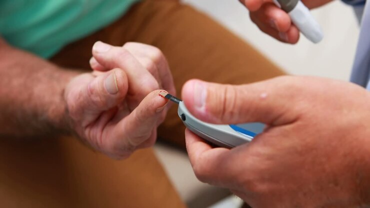Mid-section of doctor examining senior patient blood sugar