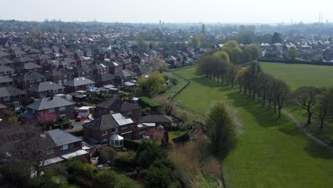 Countryside-housing-estate-aerial-view-flying-above-England-farmland-residential-suburb-homes