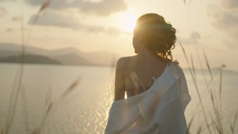 woman contemplating the sunset over the water