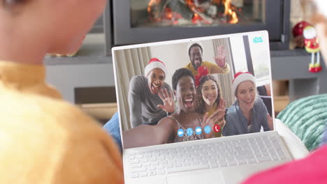 felices amigos diversos teniendo navidad llamada de video portátil, cámara lenta