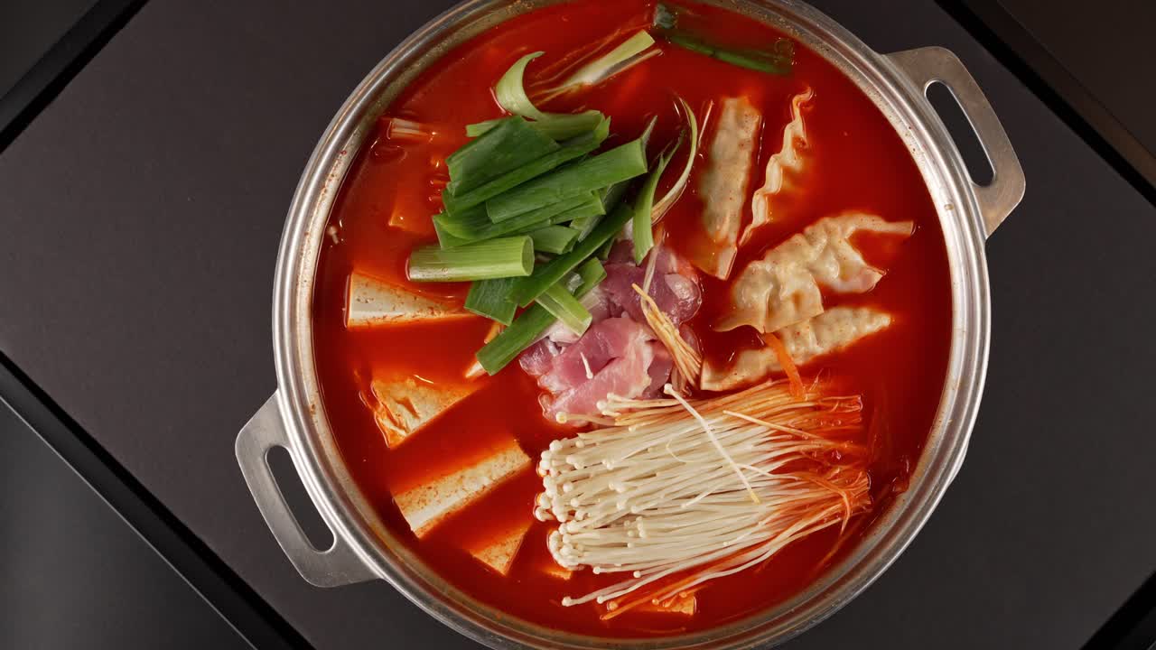 A hearty, spicy stew with aged kimchi, tender meat, and fresh vegetables in a rich broth. 숙성 김치와 부드러운 고기가 어우러진 얼큰한 찌개, 진한 국물의 깊은 맛.