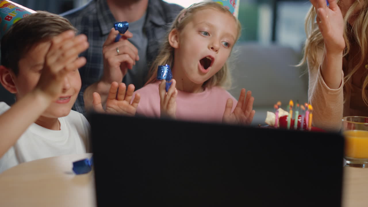 가정 파티에서 휘파람을 불어넣는 가족, 가상 파티를 즐기는 부모, 아이들.