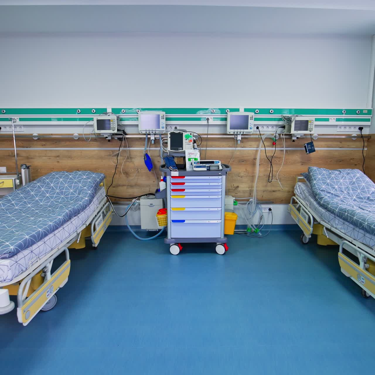 Two empty wheeled beds in the resuscitation room. Machines and devices with turned off monitors at the walls and besides