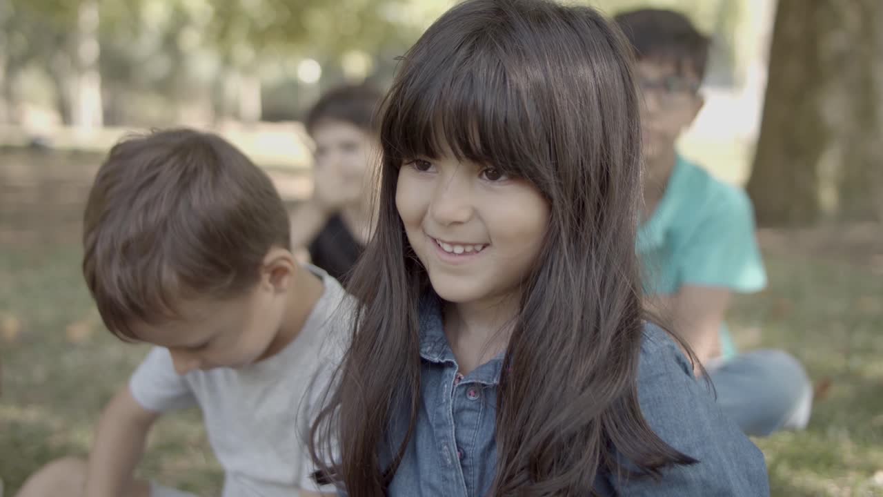 친구와 함께 공원에서 잔디에 앉아 사랑스러운 라틴 소녀