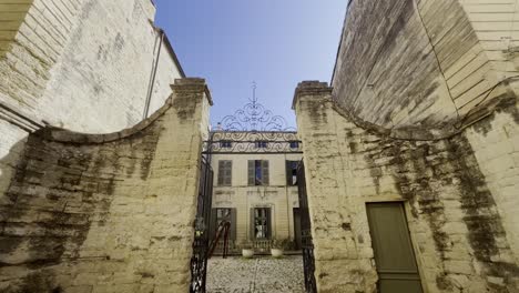 Metal-gate-and-stone-wall-with-large-property-behind-it-small-end-large-house-with-beautiful-decorations-in-France-in-your-small-town