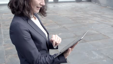 experienced female investor watching financial data via tablet