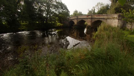 wide-shot-of-an-old-mediaeval-stone-bridge-in-the-village-of-Ilam