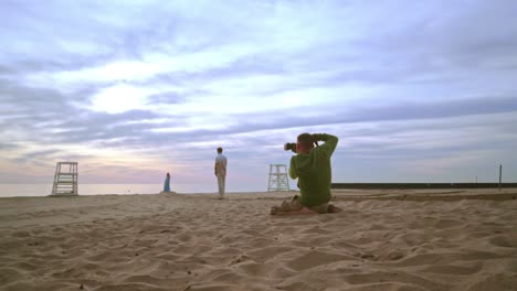 fotógrafo tomando una foto de una pareja en la playa. sesión de fotos románticas