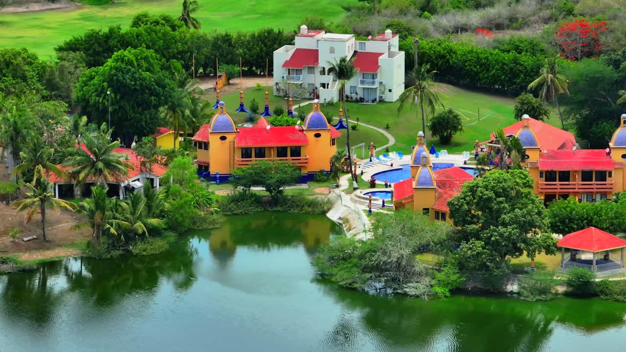 Mexican traditional orange buildings, lagoon, palm trees, and greenery in Flamingos Residencial Bucerias, Nayarit, Mexico