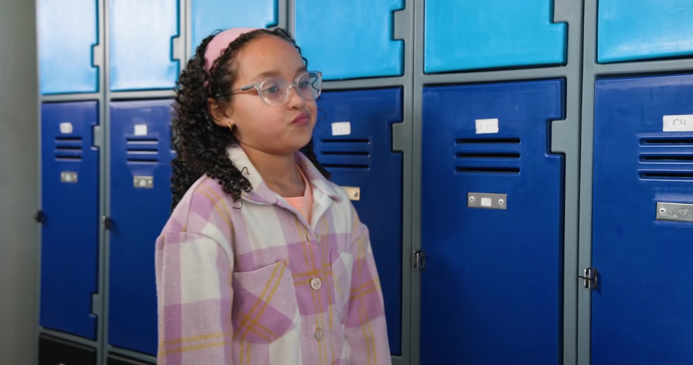 Teen African American arriving at school lockers opening locker and getting books from backpack