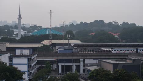 time lapse of moving train with mosque or masjid on background on cloudy weather in malaysia