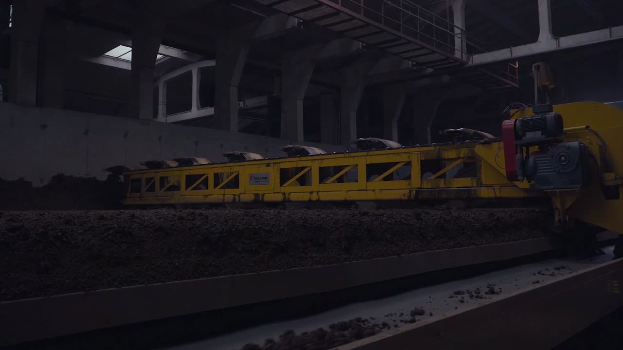 cinta transportadora industrial que transporta materiales a granel en una fábrica