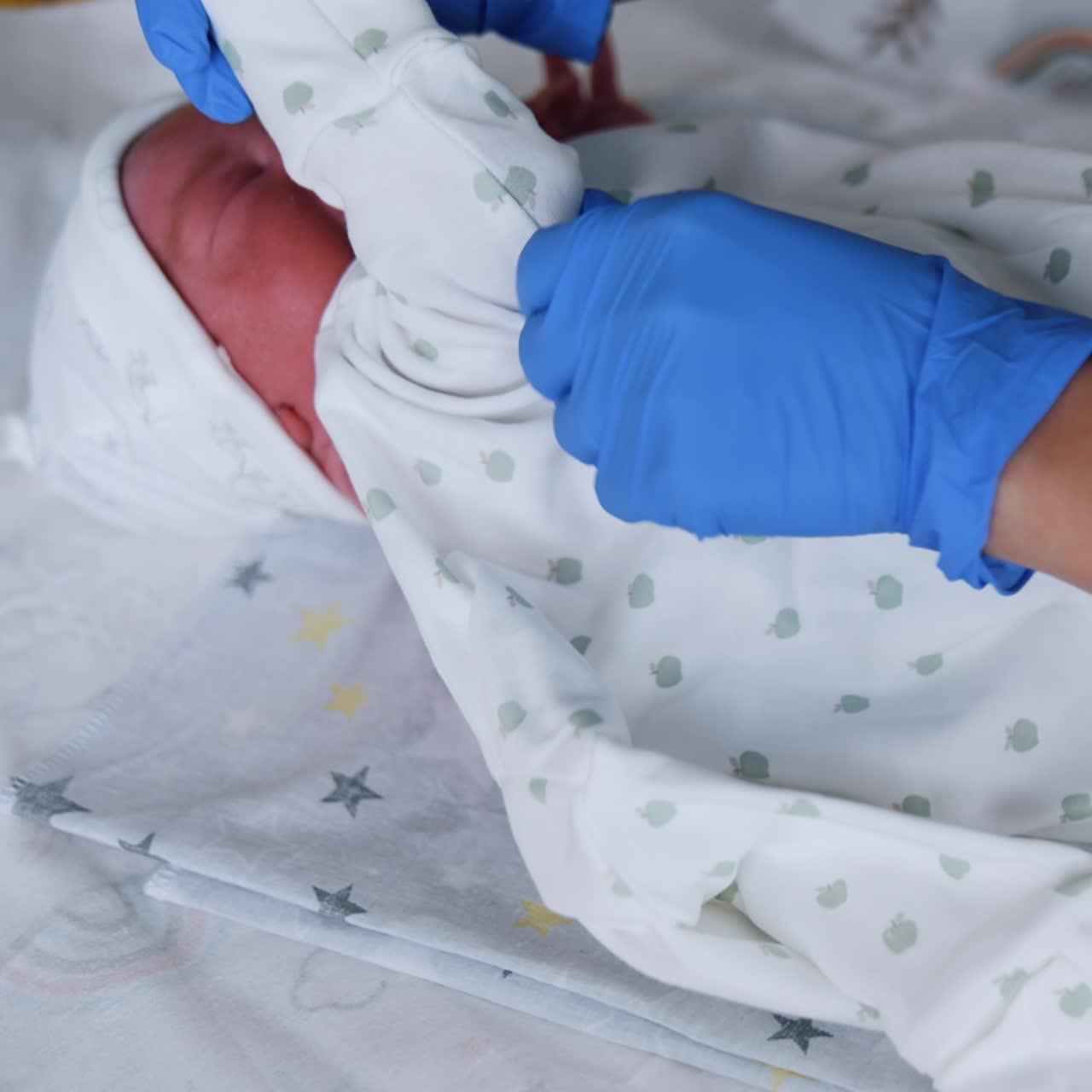 Un adorabile neonato caucasico sbadiglia mentre l'infermiera lo veste. Cura di un neonato dopo la nascita in ospedale. Primo piano