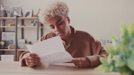 african female reading paper letter feeling excited of getting good news