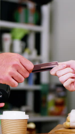 customer making payment through payment terminal machine at counter