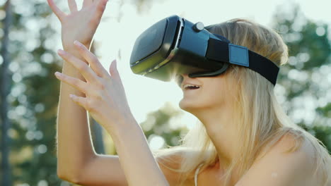 young woman in a helmet of virtual reality touching invisible wall