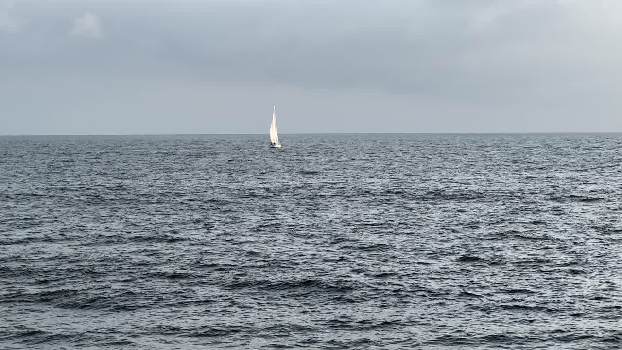 화이트 세일보트 (white sailboat) 는 암울한 캘리포니아 날에 태평양에서 바람을 항해하고 있다.