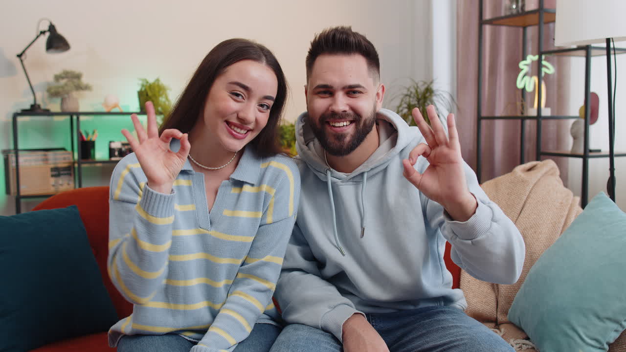 Happy cheerful family man woman looking approvingly at camera showing ok gesture positive like sign
