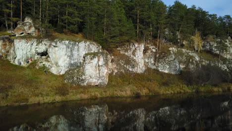 rocky riverbank with forest and reflections