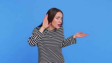 caucasian woman trying hear you looking confused and frowning keeping arm near ear for louder voice