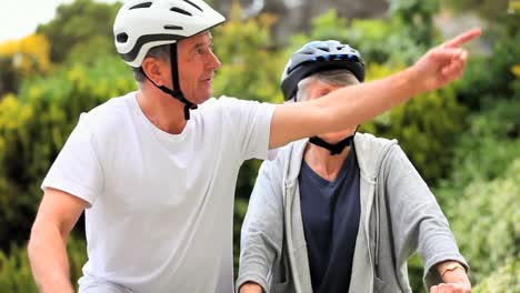 mature couple on bycycles having a break