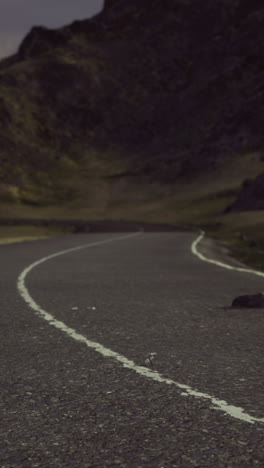 Winding road through mountainous terrain under a dusky sky at twilight
