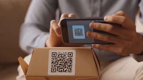 person scanning qr code on a package with a smartphone