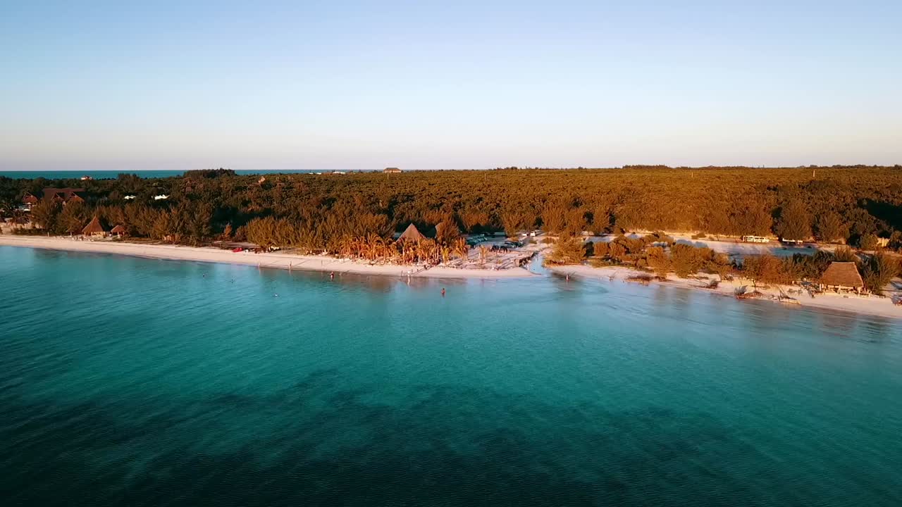 Smooth slowly sinking down drone shot in front of a dream festival party beach bar hig