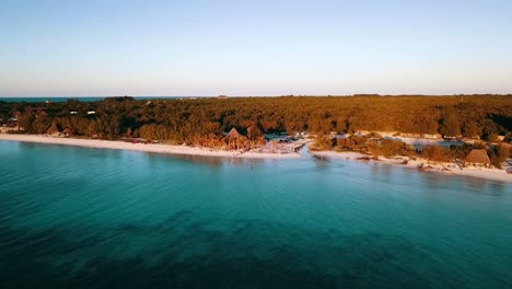 disparo de dron que se hunde lentamente frente a un festival de ensueño, fiesta, bar en la playa, alto
