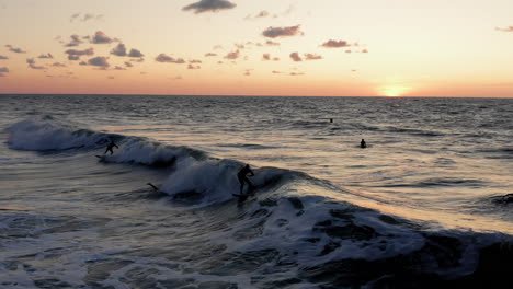 surfistas frente a la ciudad turística domburg en los países bajos durante la puesta de sol