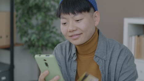 person using mobile phone and credit card for online shopping.