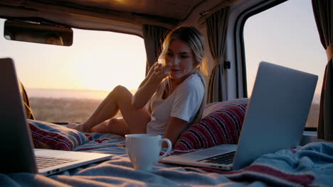 digital nomad lifestyle: woman working and relaxing in van at sunset