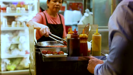 vendor prepares food for a waiting customer