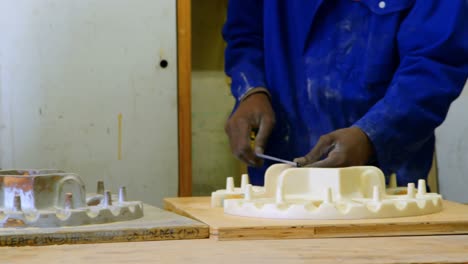 Workers-discussing-over-metal-casting-mold-in-workshop-4k