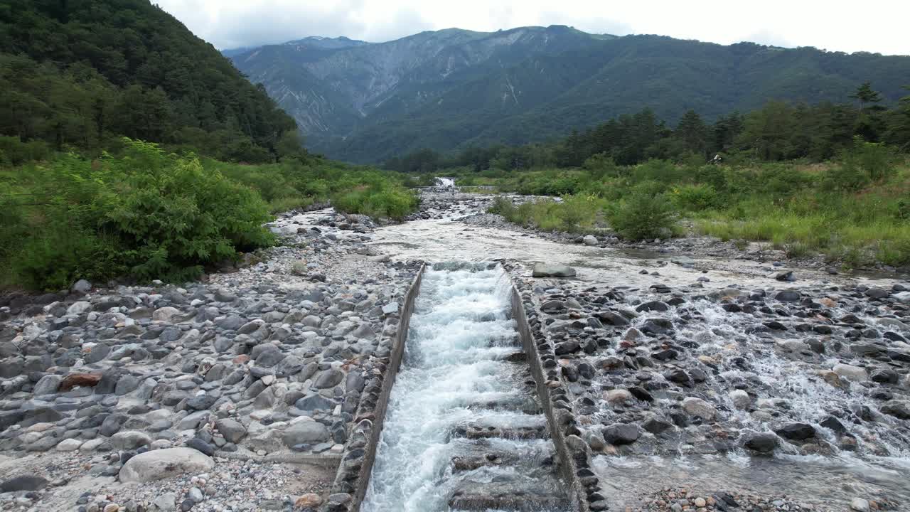 Matsu Rocky River Rapidly Flows Over Rocks During Summer In Nagano, Kitaazumi District, Hakuba, Japan. Aerial Pullback Shot