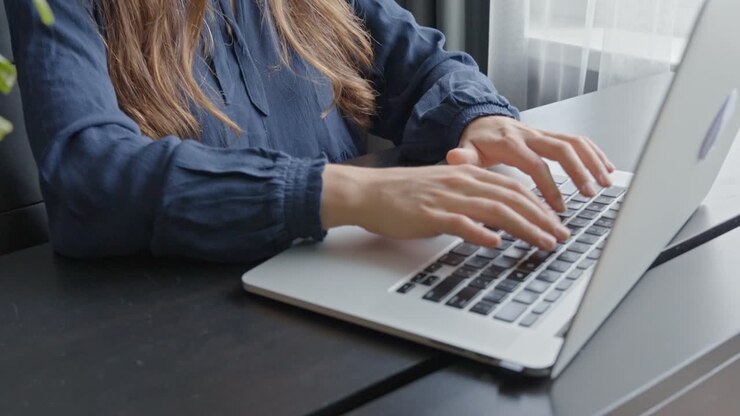 Ung kvinde arbejder på en bærbar computer på et lille, elegant kontor, i slow motion
