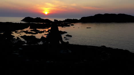 paradise during sunset reveals a figure meditating by the sea