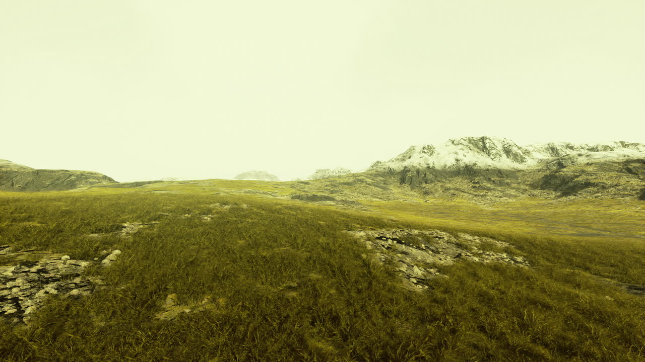 Golden grasslands and mountains beneath a cloudy morning sky
