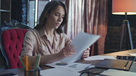 uitgeput financiële analist die grafieken met bedrijfsstatistieken bestudeert