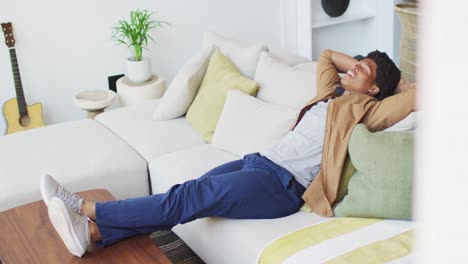 Happy-african-american-man-resting-and-relaxing,-siting-on-the-couch