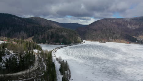road in snow covered forest, top down aerial view