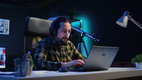 remote employee writing emails at home office desk while listening music