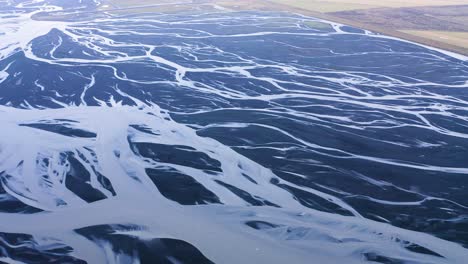 cinematic aerial shot of iced markarfljo t river delta during bright sunny day in iceland