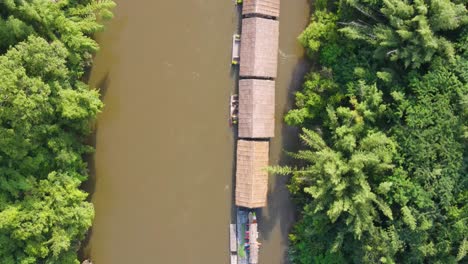 Vista-Aérea-De-Arriba-Hacia-Abajo-De-Varios-Hoteles-Flotantes,-En-El-Río-Kwai-Rodeado-De-Selva,-Kanchanaburi,-Tailandia