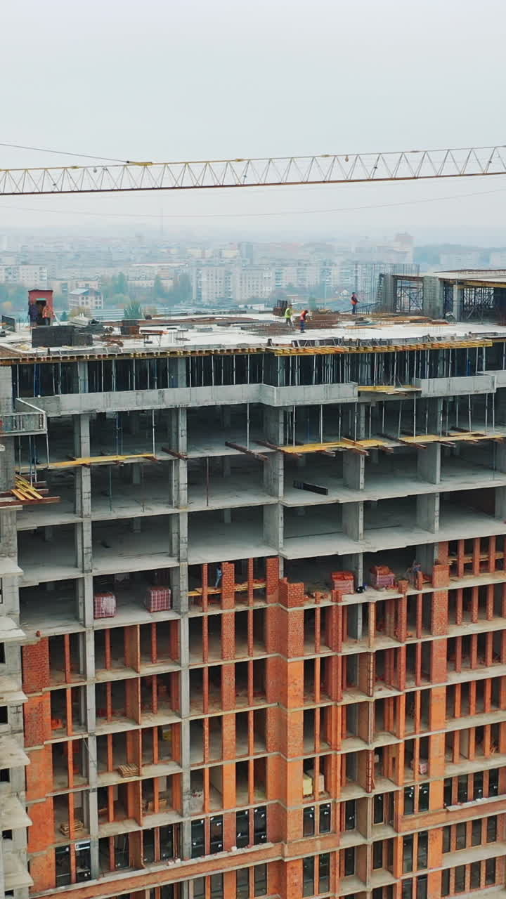 Construction site from height. Drone aerial view of new development with cityscape in background
