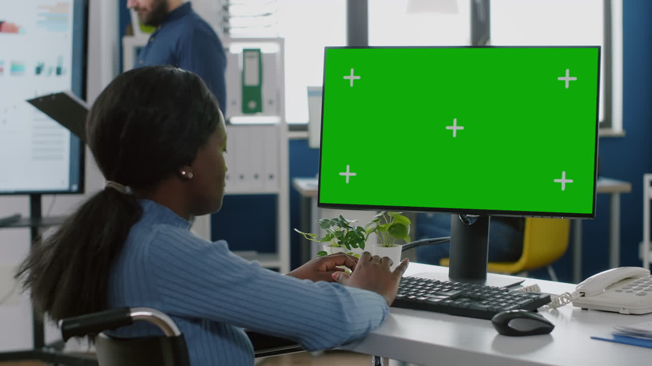Afrikansk handicappet forretningskvinde ser på chroma key desktop