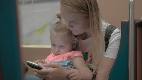 Mum-using-cellphone-during-subway-ride-with-little-daughter